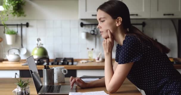 Mutfakta duran kadın dizüstü bilgisayarı sorun çözümü üzerinde düşünün — Stok video