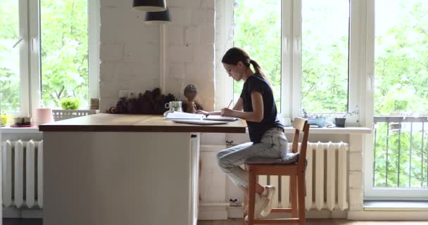 Девочка учится на дому, пишет заметки, готовит университетское эссе — стоковое видео