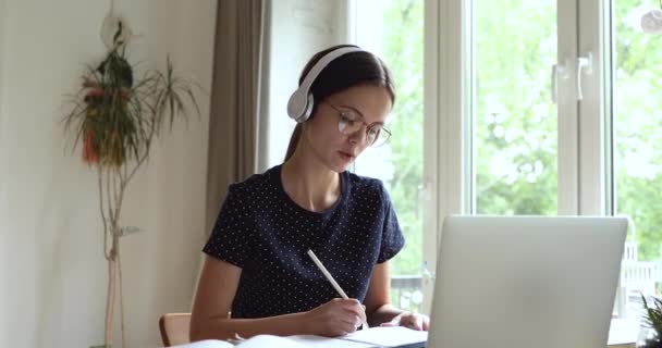 Studerande studerar använda bärbar dator notera prata med skolkamrat genom videokall — Stockvideo