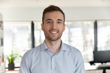 Ofiste poz veren beyaz erkek çalışanın profil fotoğrafı.