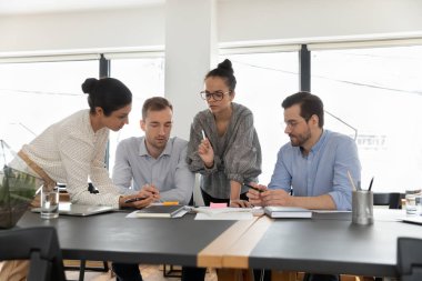 Genç çeşitli meslektaşlar ofiste iş birliği yapıyor.