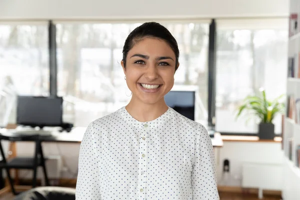 Headshot portrait of indian female employee posing in office