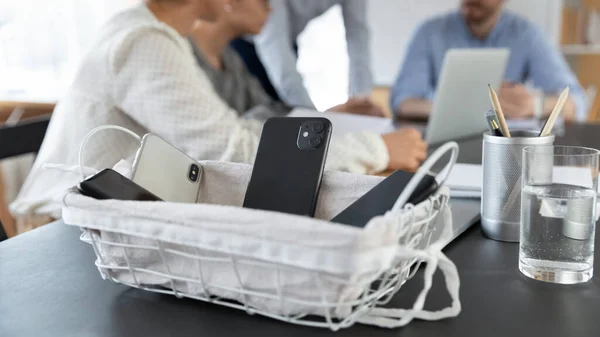 Крупним планом смартфони в коробці на засіданні командного офісу — стокове фото