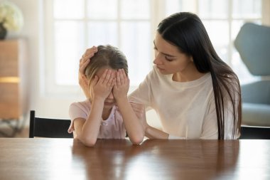 Annesini önemseyen, sakinleştiren ve küçük kızını kucaklayan.