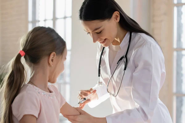 Gülümseyen kadın çocuk doktoru küçük kızı hastanede aşılıyor. — Stok fotoğraf