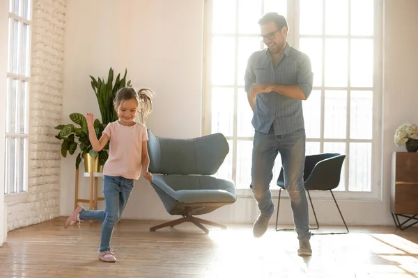 Gelukkig vader en schattige kleine dochter dansen in de woonkamer — Stockfoto