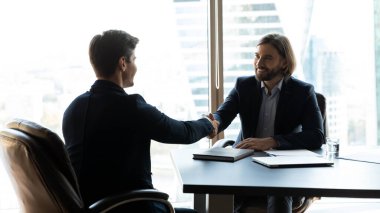 Mutlu iki iş ortağı buluşmada tokalaşıyor..