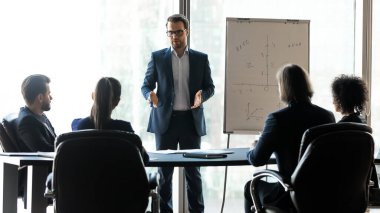 Kendine güvenen erkek lider koçu farklı takım arkadaşlarını yönlendiriyor..
