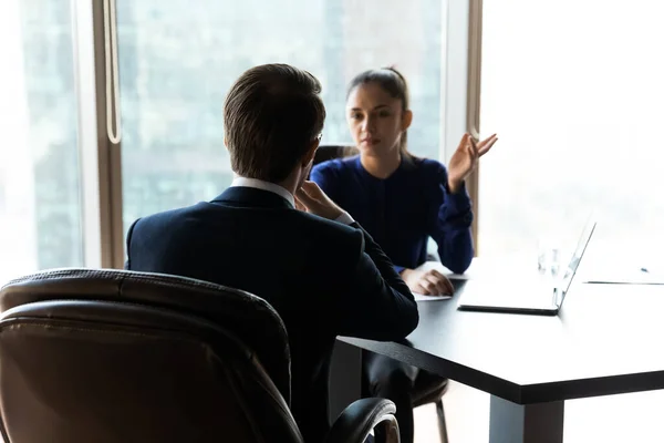 Konzentrierter Geschäftsmann diskutiert mit Partnerin über Arbeitsfragen. — Stockfoto