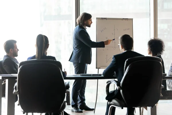 Jonge mannelijke baardbedrijfstrainer die marketingonderzoeksresultaten uitlegt. — Stockfoto