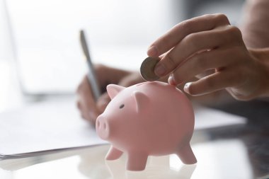 Close up of woman save put money in piggy bank clipart