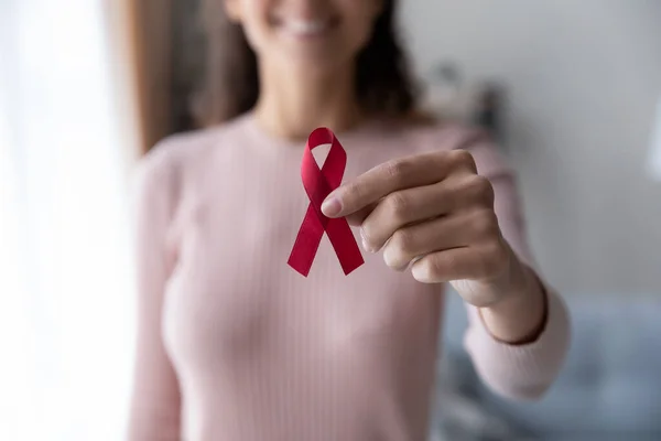 Primo piano della donna tenere il nastro rosso simbolo del cancro — Foto Stock