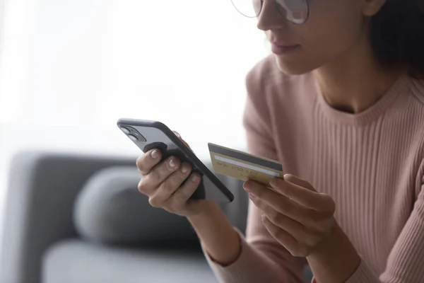 若い女性はクレジットカードで支払うスマートフォンを使用します。 — ストック写真