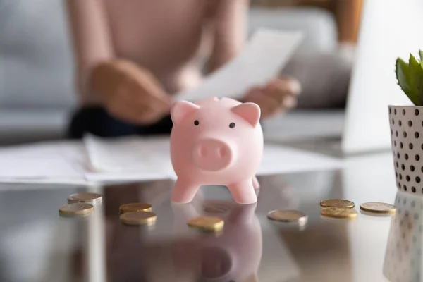 Close up of piggy bank on table with coins — Stock Photo, Image