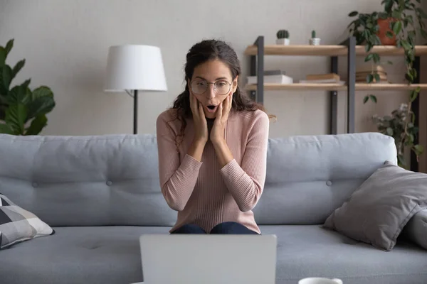 Mujer joven aturdido sorprendido por las noticias en el ordenador portátil — Foto de Stock