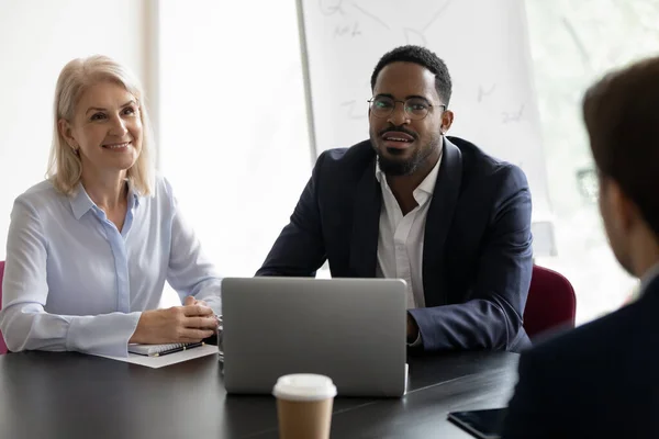 Afrikaanse en volwassen HR-managers die sollicitant luisteren tijdens sollicitatiegesprek — Stockfoto