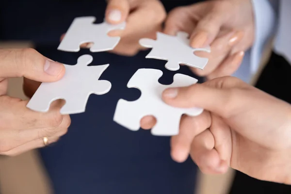 Closeup hands holding white pieces of puzzles find right solution — Stock Photo, Image