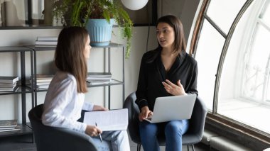 Çok ırklı kadın çalışanların beyin fırtınası ofiste işbirliği yapıyor.