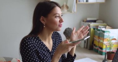 Akıllı telefon uygulaması kullanan genç bir kadın sesli mesaj kaydediyor.