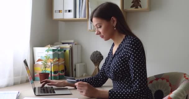 Kvinna använda laptop innehav kort göra betalning köpa på internet — Stockvideo