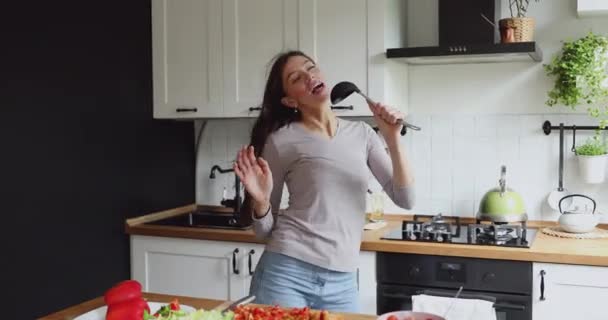 На кухне танцует женщина поет песни с помощью ковш, как микрофон — стоковое видео
