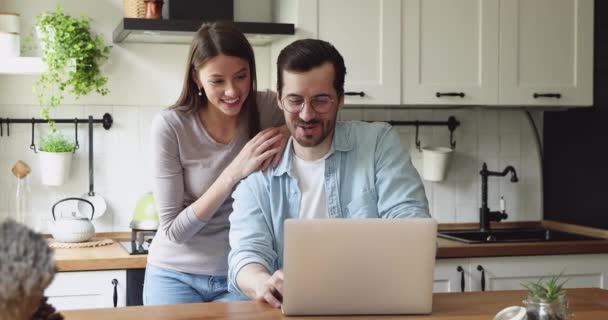 Ehepartner nutzen Laptop und freuen sich über Erfolg — Stockvideo