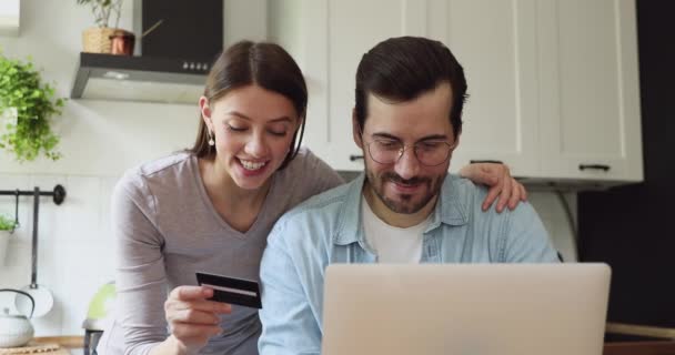 Cuplu pe bucătărie folosind laptop și card de cumpărare bunuri on-line — Videoclip de stoc