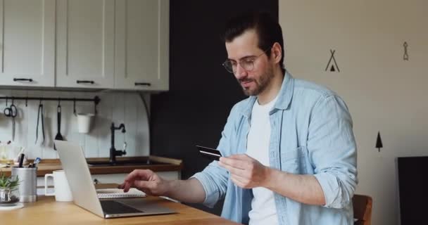 Uomo in possesso di carta di credito uso laptop rende il pagamento online sicuro — Video Stock