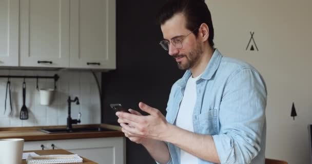 Man som håller smartphone njuta avlägsen informell trevlig chatt med vän — Stockvideo