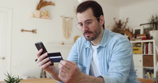 Homem segurando cartão de crédito usar celular comprar bens na internet — Vídeo de Stock