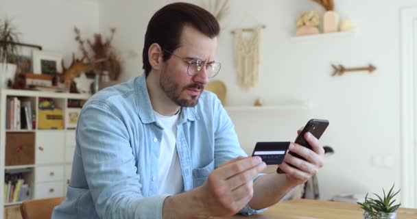 Homme tenant smartphone carte de crédit ayant des problèmes avec la transaction d'argent — Video