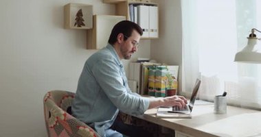 Adam internette bilgi arar ve not defterine yazar.