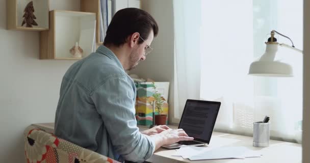 Freelancer escribiendo usando laptop lograr trabajo relajante apoyado en silla — Vídeo de stock