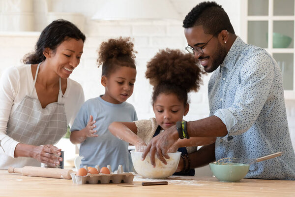 Happy african american family with kids baking at home