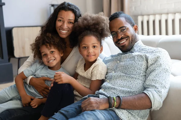 Koltukta çocuklu mutlu bir çift ırklı ailenin portresi. — Stok fotoğraf
