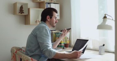 Akıllı telefonu elinde tutan adam hoparlörden konuşuyor. İş arkadaşınla belgeleri tartışıyor.