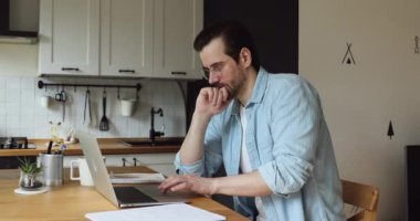 Düşünceli iş adamı laptopta çalışırken şüpheli görünüyor, arama sorunu çözümü