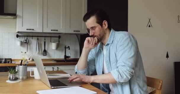 Pensive zakenman werk op laptop voelt twijfelachtig, zoeken probleem oplossing — Stockvideo