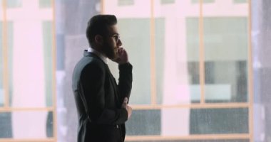 Kendine güvenen Arap işadamı ofiste konuşurken takım elbise giyiyor.