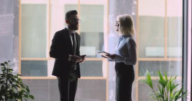 Genç erkek ve yaşlı iş arkadaşları konuşuyor.