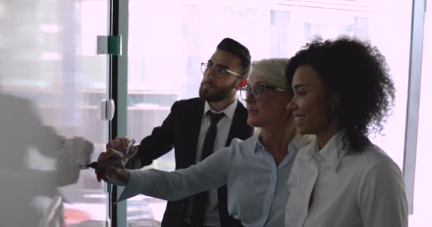 Femme d'affaires d'âge moyen leader expliquant l'écriture de stratégie sur tableau blanc — Video