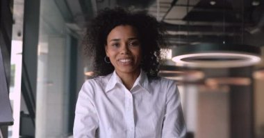 Gülümseyen mutlu Afro-Amerikan melez iş kadını danışman müşteriyle konuşuyor.