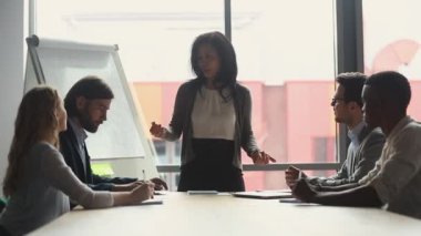 Olgun Asyalı iş kadını yöneticileri şirket toplantısında çalışanlarla konuşur.