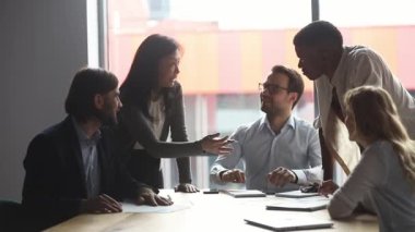 Orta yaşlı Asyalı kadın lider toplantı sırasında şirket stratejisini açıklıyor