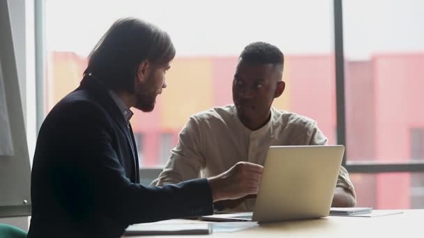 Manlig kaukasiska mentor lära afrikansk praktikant med bärbar dator — Stockvideo