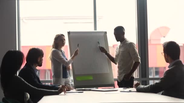 Zwei unterschiedliche Konferenzsprecher halten Flipchart-Präsentation — Stockvideo