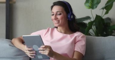 Kulaklık takan kadınlar, arkadaşlarıyla video konuşmalarıyla selamlaşırlar.