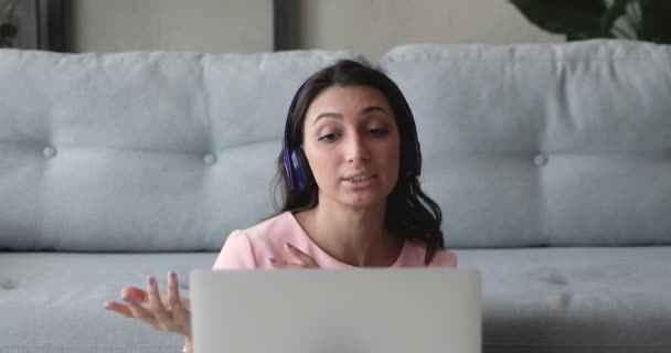 Kobieta nosić słuchawki cieszyć rozmowy na odległość za pomocą videocall i laptopa — Wideo stockowe