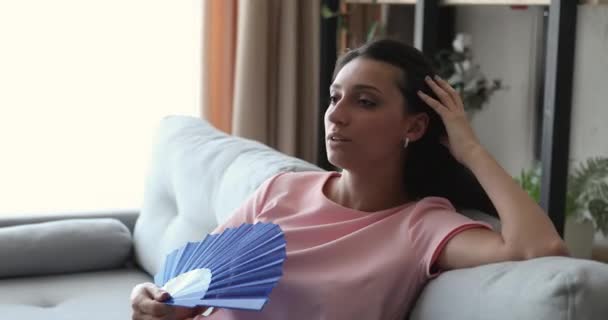 Tormented by hot weather Indian woman using fan cooling herself — Stock Video