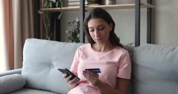 Donna uso carta di credito in possesso di smartphone rende l'acquisto si sente soddisfatto — Video Stock